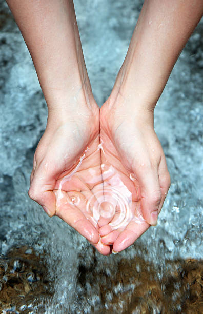 Home woman's hands over a water cascade