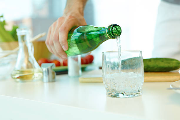 Home man pouring mineral water in glass
