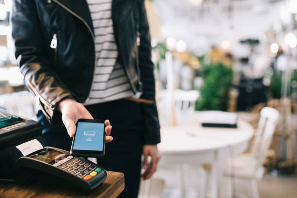 Home woman using smartphone to pay in a store. close up.